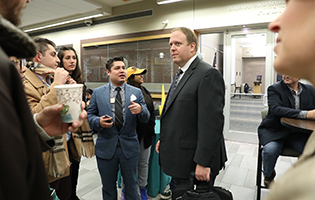 Five students talking to a man with a briefcase