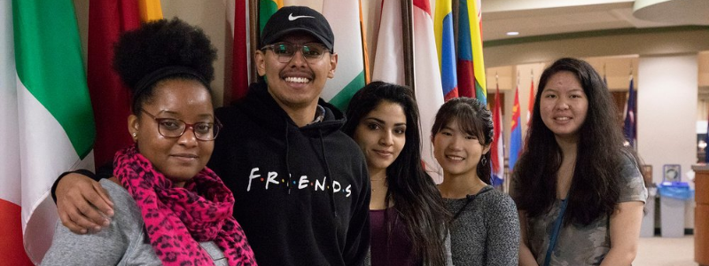 Students Standing In Front of Flags