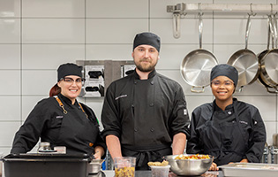 three Brightwater studnets in a kitchen smiling