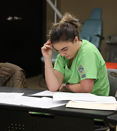 Female Student Reading Book on Table