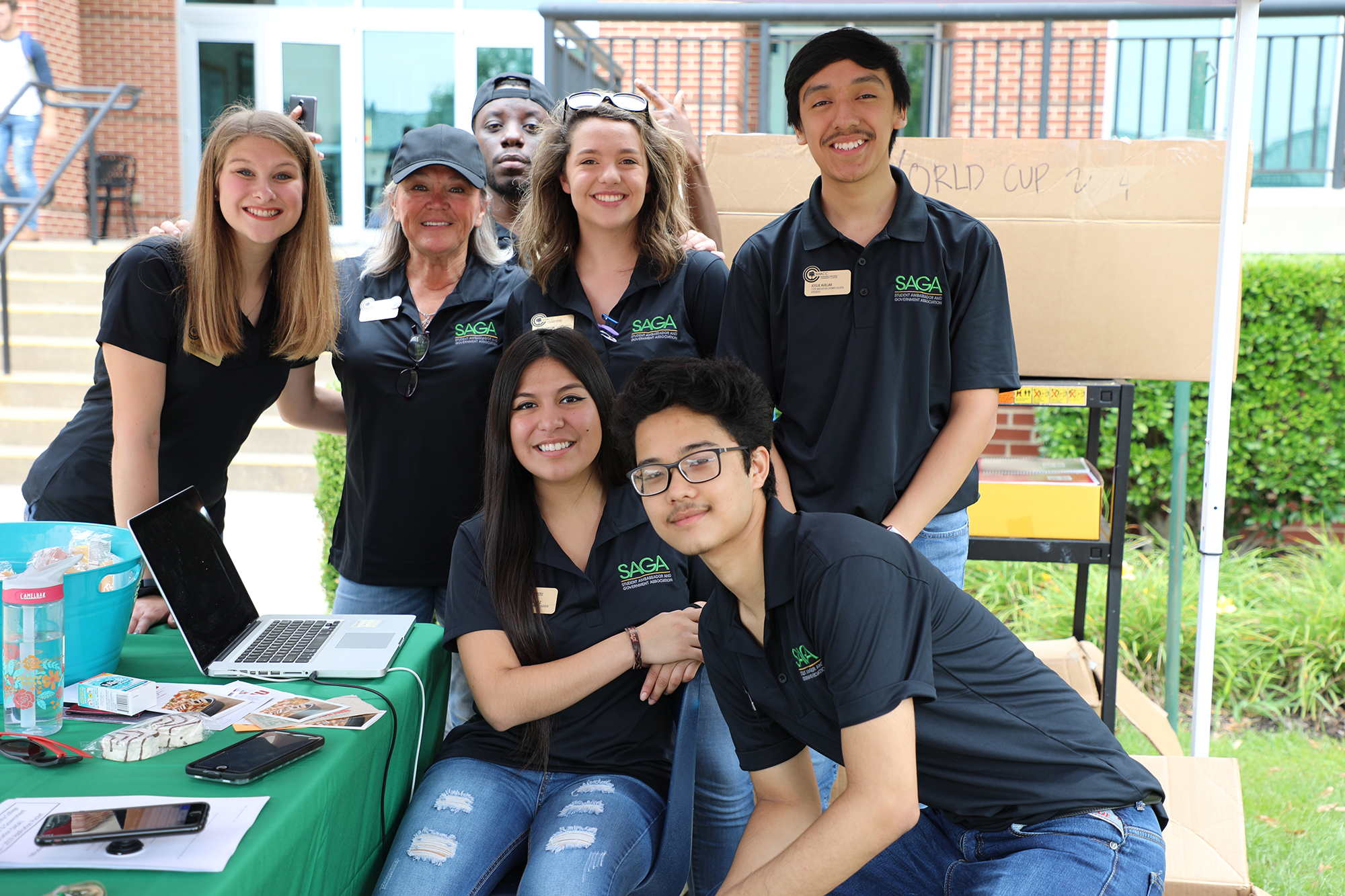 Group of student ambasadors smiling for the camera while under a tent at an event