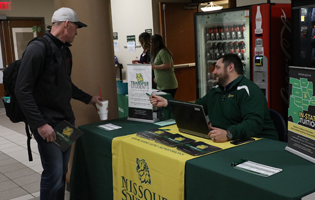 A Student Speaking to a Man at a Table